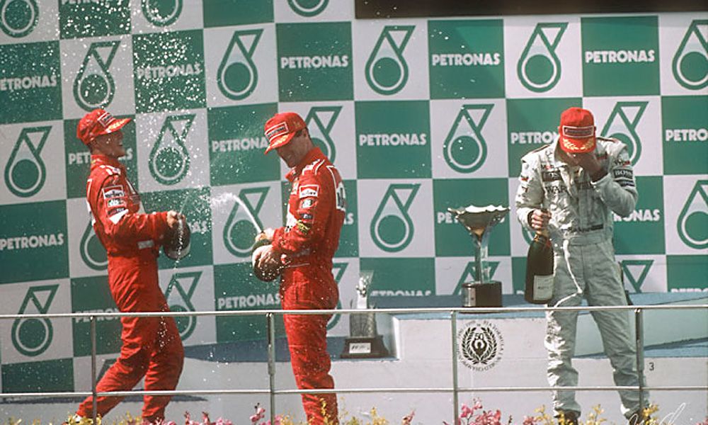 Michael Schumacher, Eddie Irvine and Mika Hakkinen on the podium - 1999 Malaysian Grand Prix at Sepang